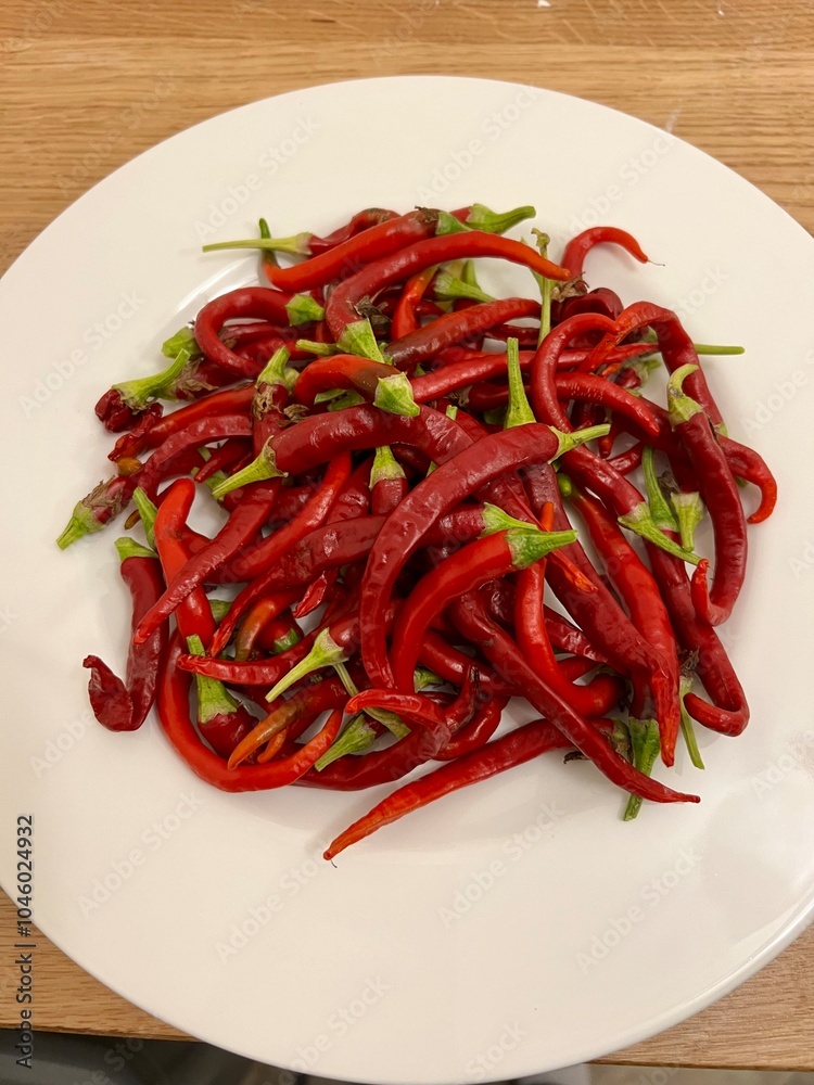 Chili pepper harvest on white plate Chili pepper harvest on white plate