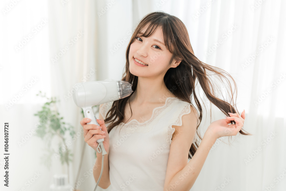 Φωτογραφία ヘアドライヤーでヘアブロー・髪の毛を乾かす女性（ヘアケア）