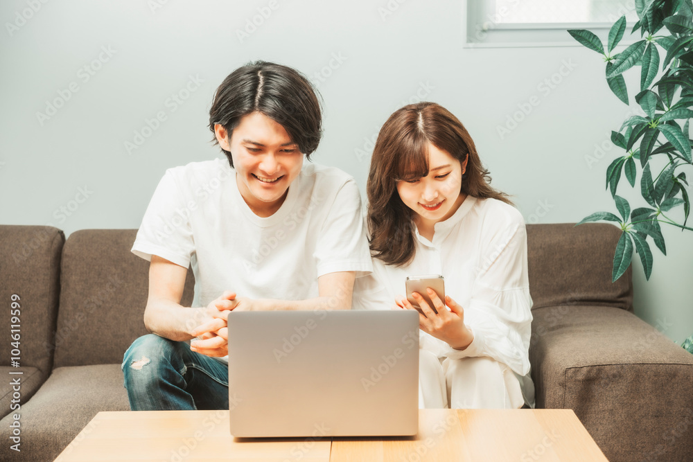 ノートパソコンとスマホを使う男女
ノートパソコンとスマホを使う男女