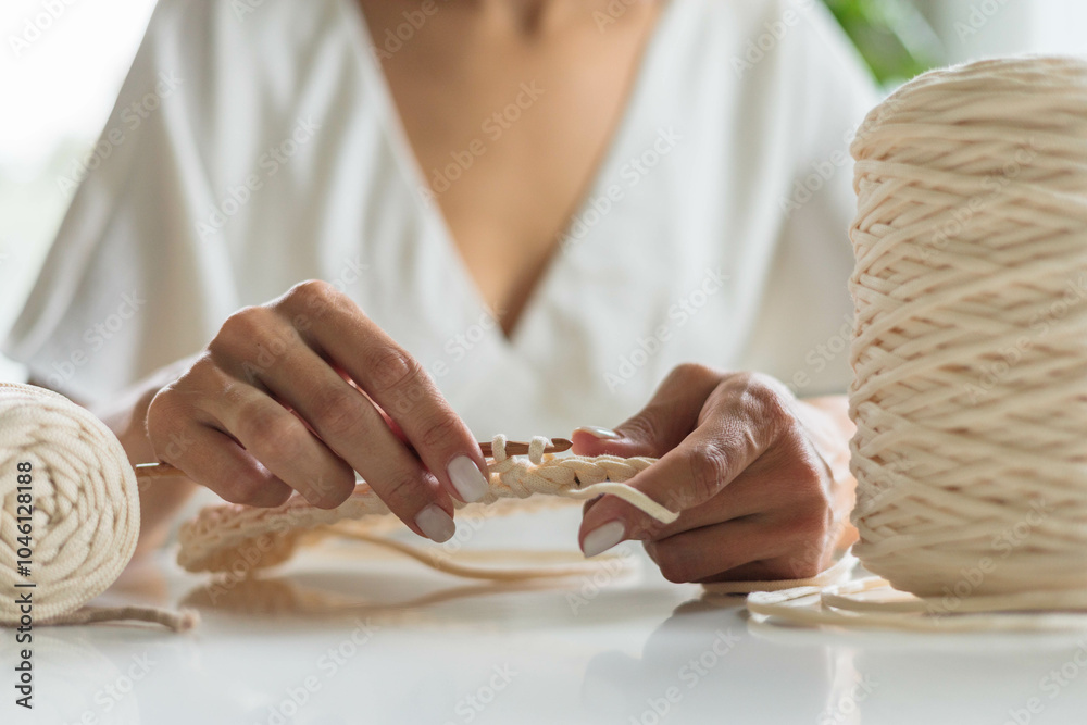 Obraz premium Close-up of a young girl's hands in a white dress. The woman crochets the bottom 