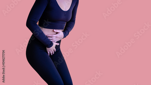 Female suffering from lower abdominal pain and is in distress and hunched over and holding her belly. This could be caused by a multiple factors, such as endometriosis, PCOS, IBS, UTI or constipation. photo
