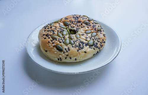 Delicious soft whole grain bread on a white plate on a white background.