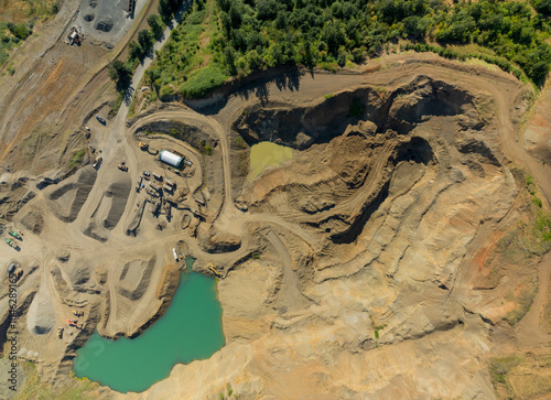 A large open pit mine with a pond in the middle photo