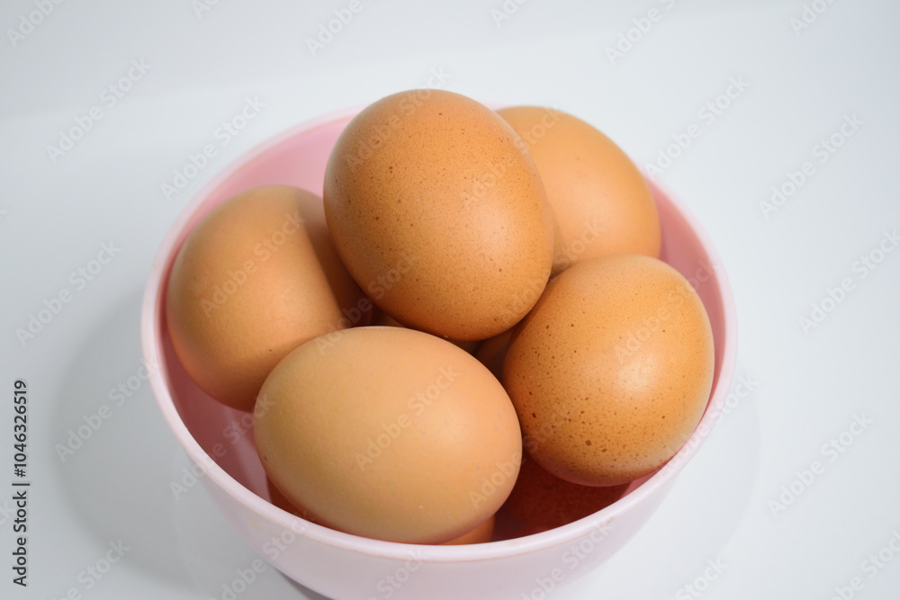 Close up view of chicken eggs in the pink bowl isolated on white background Close up view of chicken eggs in the pink bowl isolated on white background