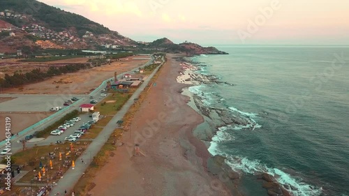 Aerial Drone Flyover Along Koru Beach in Gazipasa, Turkey, Capturing the Shoreline and Gentle Waves in Soft Sunset Light, Serene Coastal Scene with Tranquil Sea photo