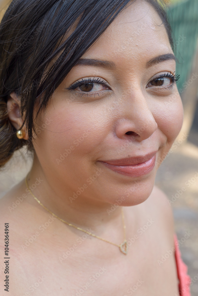 Naklejka premium Smiling Woman with Long Black Hair and Gold Necklace. Close up.