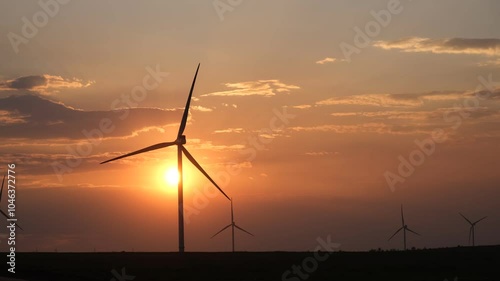Wind turbines at sunset. Wind turbines in the orange sky. Rural areas with renewable energy sources. The concept of environmental safety green energy. Landscape with windmills. Sustainable development