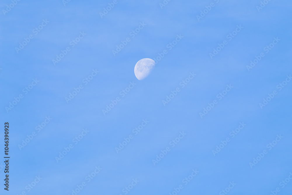 A beautiful crescent moon in daylight against a clear blue sky. A beautiful crescent moon in daylight against a clear blue sky.