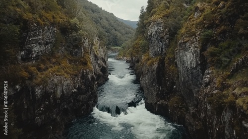 A dramatic mountain scene with steep cliffs and a rushing river, surrounded by lush greenery