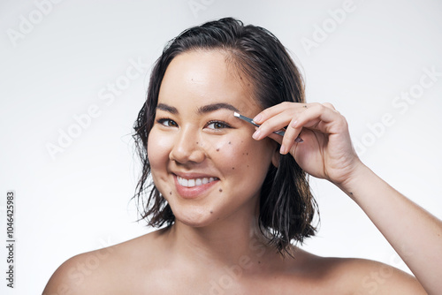 Happy, portrait and asian woman with tweezer for eyebrows, hair removal or beauty on a white studio background. Young beautician, female person or gen z model with pincers for brow shape or grooming photo