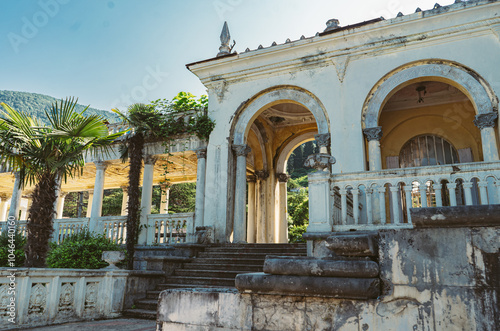 colonnade of abandoned train station in abkhazia, Gagra. Mountains scenery on background photo