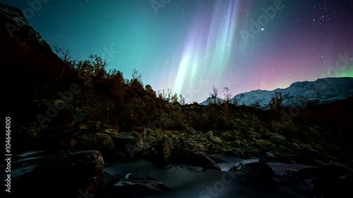 Mesmerizing motion nightlapse over Lakselvbukt river with vivid aurora borealis photo