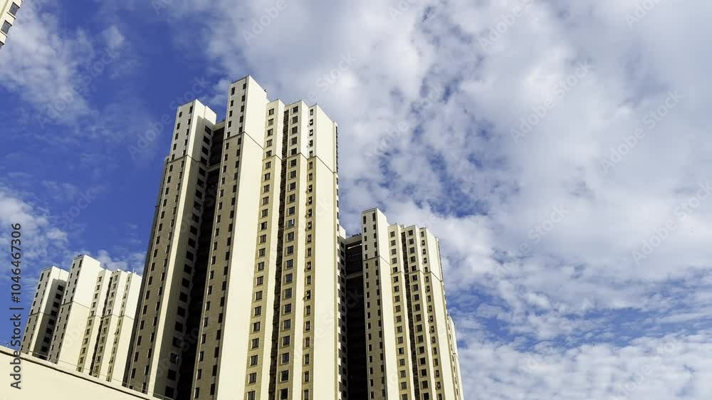 The video showcases a apartment buildings, framed by gray clouds contrasting with the blue sky The video showcases a apartment buildings, framed by gray clouds contrasting with the blue sky