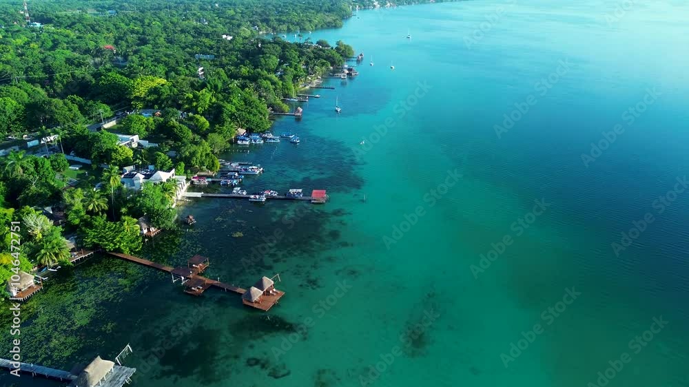 Drone aerial landscape of Bacalar town village with resort hotel buildings with private boardwalk jetty wharf on lagoon lake bay cenote Mexico Quintana Roo travel holidays