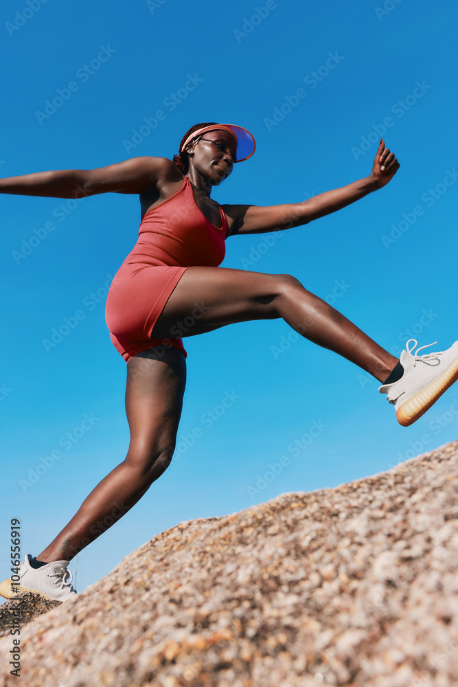 Athletic woman in a red outfit energetically climbing a rock against a clear blue sky Athletic woman in a red outfit energetically climbing a rock against a clear blue sky