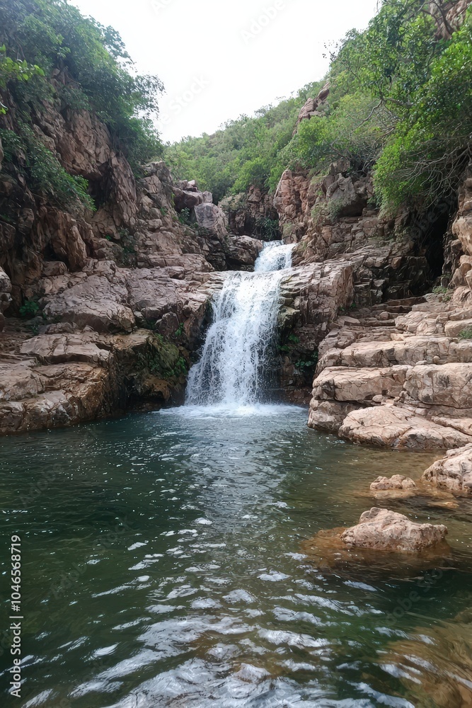 A stunning view of a mountain waterfall cascading over rocks into a clear pool, surrounded by lush trees. Ideal for nature and adventure themes. A stunning view of a mountain waterfall cascading over rocks into a clear pool, surrounded by lush trees. Ideal for nature and adventure themes.