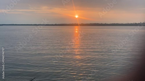 Drone timelapse of a boat crosses the river with a sunset scene background in Calabar, Nigeria photo