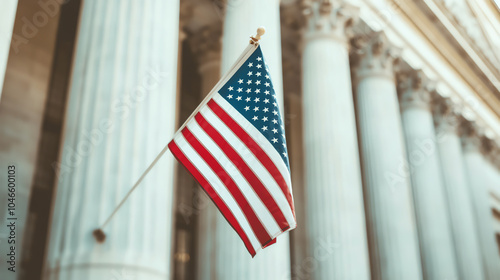 An American flag waves gracefully in front of majestic columns, symbolizing patriotism and heritage against a stunning architectural backdrop.