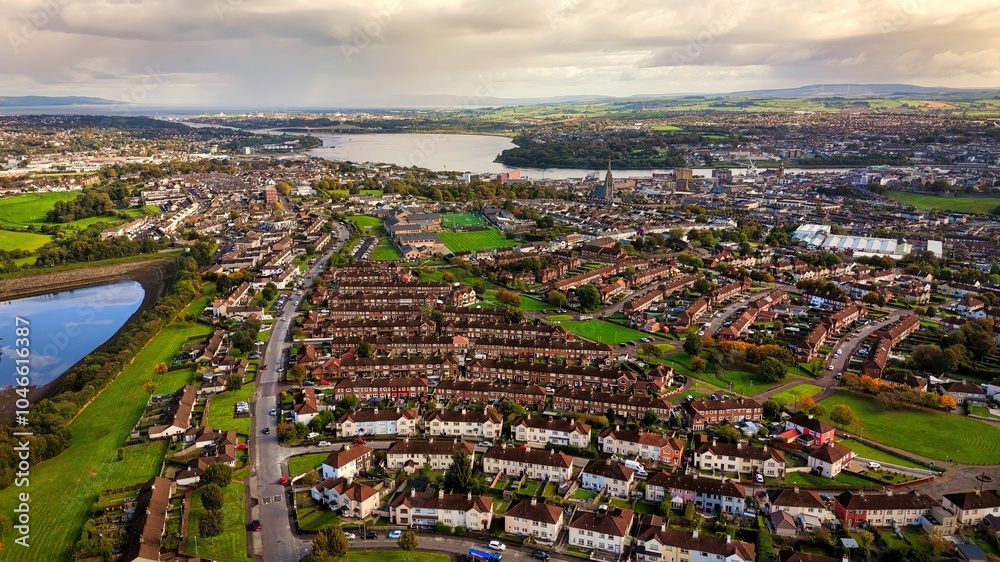 Fototapeta premium City of Derry aka Londonderry in Northern Ireland aerial view - A Dramatic Cityscape by the River Foyle Featuring a Beautiful Pedestrian Bridge