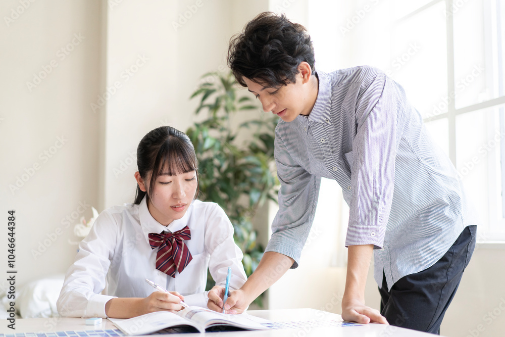 家庭教師に勉強を教わる学生 家庭教師に勉強を教わる学生