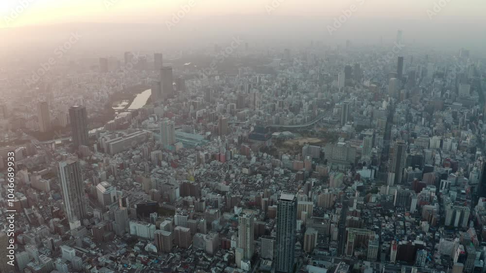 Panning aerial view over Osaka city with many skyscrapers in the morning. Osaka is the capital city of Osaka Prefecture, the second largest metropolitan area in Japan. Panning aerial view over Osaka city with many skyscrapers in the morning. Osaka is the capital city of Osaka Prefecture, the second largest metropolitan area in Japan.