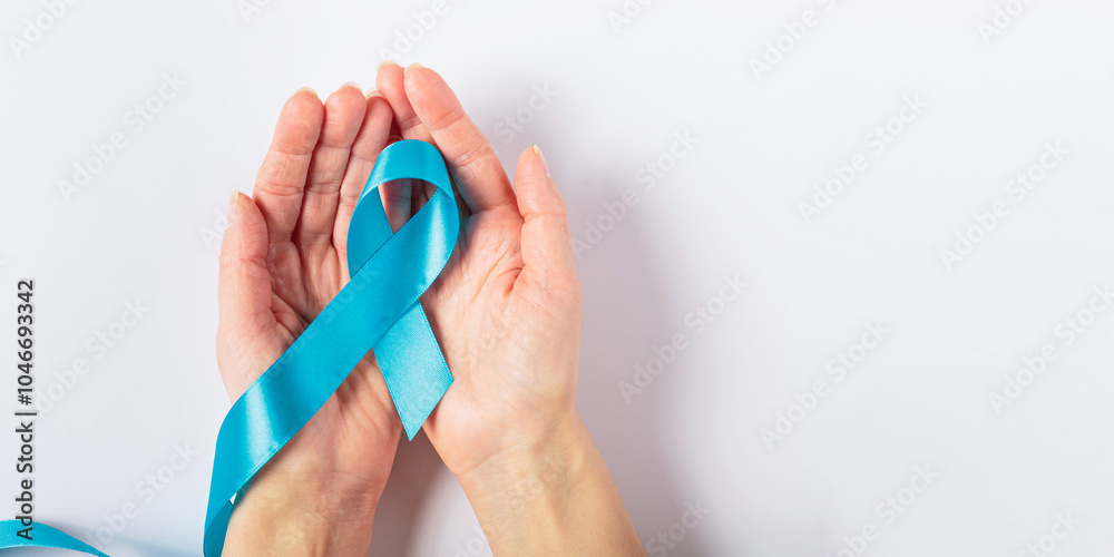 custom made wallpaper toronto digitalA close-up of a womans hand holding a blue ribbon against a white background, representing colorectal cancer awareness. Perfect for healthcare campaigns and support messages.