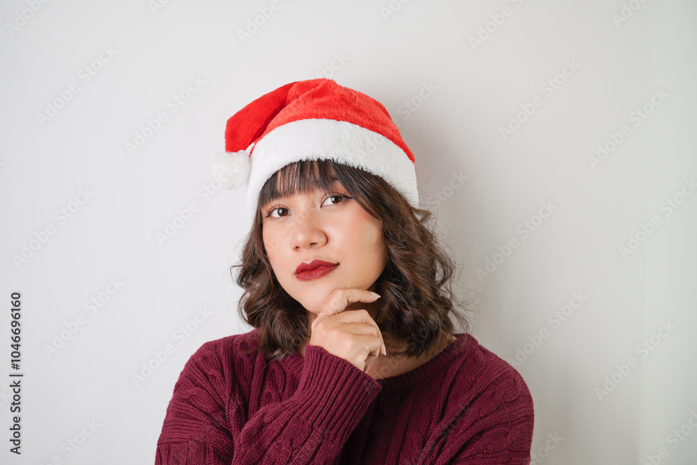 Excited young asian woman wearing santa clause hat and red long sleeved sweater with smiling face expression, isolated over white background. Concept for Christmas Holiday and New Year Party Excited young asian woman wearing santa clause hat and red long sleeved sweater with smiling face expression, isolated over white background. Concept for Christmas Holiday and New Year Party