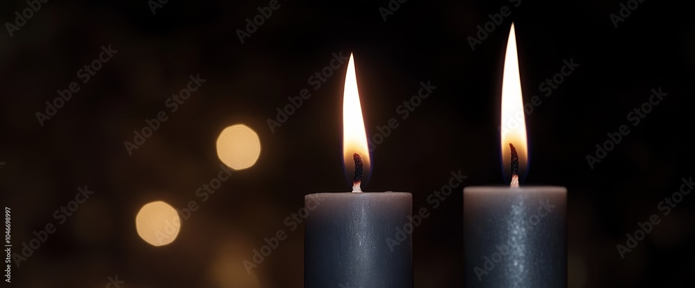 Three burning gray candles with soft bokeh in a dark, moody setting. Three burning gray candles with soft bokeh in a dark, moody setting.