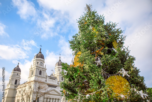 Christmas tree stands in front of a charming church. Festive holiday scene. Metropolitan Cathedral in Iasi Romania