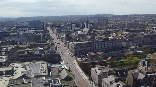 A drone captures the streets of Aberdeen, Scotland, with vehicles and pedestrians moving through the city’s historic and modern buildings. The shot showcases the vibrant urban layout from above.