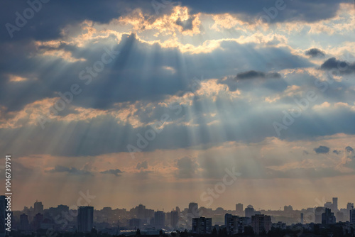 Obraz na płótnie Early morning sun rays break through thick clouds over a sleeping city. w salonie