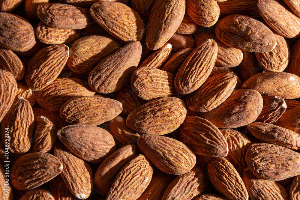 Fototapeta premium Scattered Almonds. Background from Almond Nuts. Natural High-Calorie Snacks