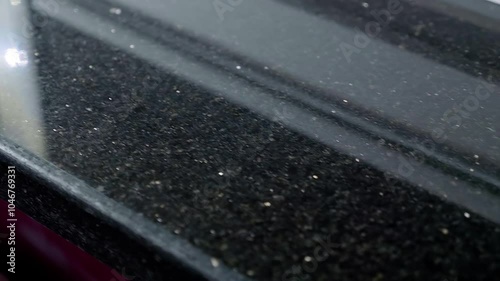 Beautiful glossy black window sill made of natural polished stone. Closeup. Macro. Shallow depth of field. Shot in motion
