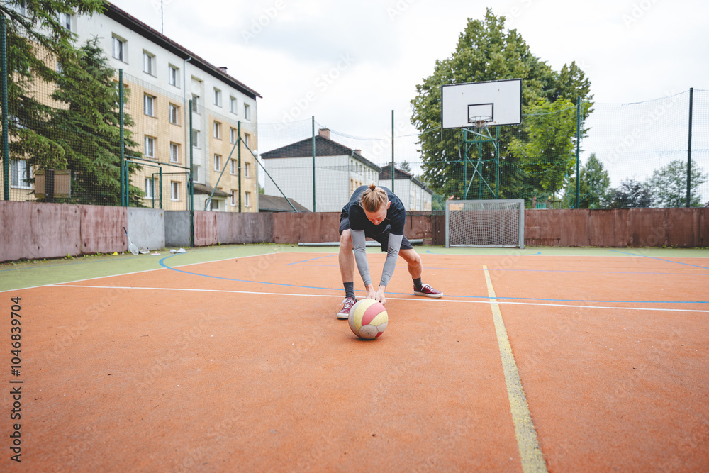 Fototapeta premium Volleyball player performing a digging on a hard court, focusing intently on the ball during an intense game. The action showcases skill, concentration, and athleticism