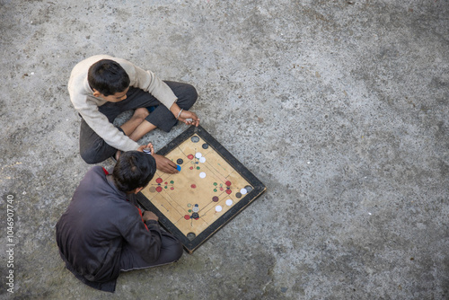 Indian village boys focus intently on a carrom board while playing together in a courtyard, surrounded by pastel-colored walls and a calming atmosphere.