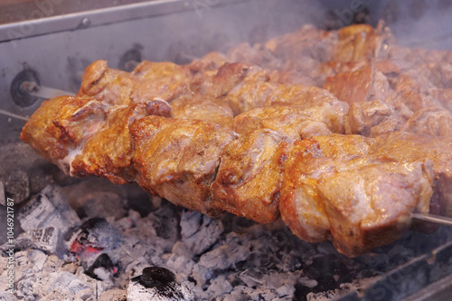 Kebabs on skewers are grilled on hot coals photo