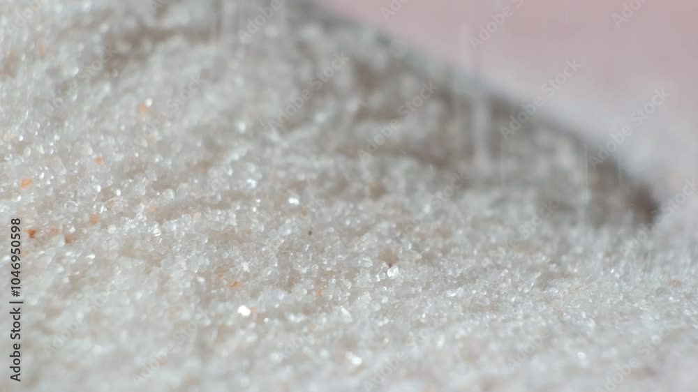 Pink Himalayan salt finely ground pouring slow motion macro. Pink Himalayan salt finely ground pouring slow motion macro.