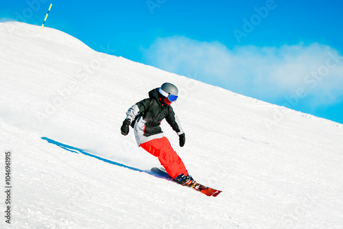 Skiing in action with no poles. Sportsman in a red black ski suit. Side view. High speed. Isolated white blue background photo