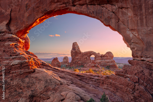 Obraz na płótnie North Window Arch, Arches National Park, Utah, USA. Landscape image of North Window Arch, Arches National Park, Utah, USA with Turret Arch in the background at autumn sunset. w salonie