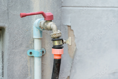 Photo of a garden faucet connected to a hose with a hose clamp to prevent it from slipping off.