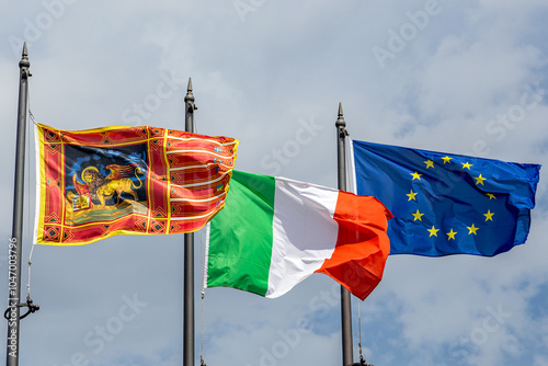 Flags of Veneto Region, Italy and European Union waving in the wind photo