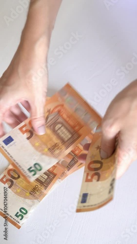 Vertical footage of a woman’s hands holding and counting 50 euro bills 