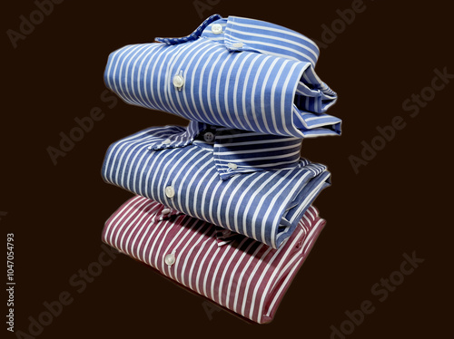 stack of striped botton down cotton shirts in different colors on brown background photo