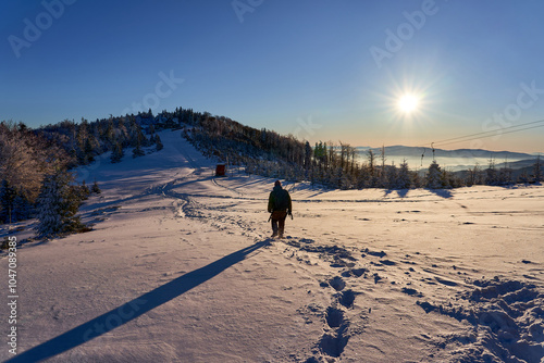 Man hiking in snowy mountains, exploring new area. Winter wonderland