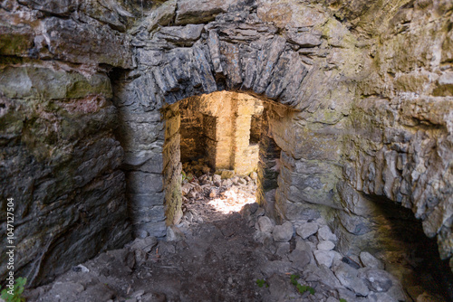 Abandoned Stone Cave Interior with Natural Light Streaming In photo