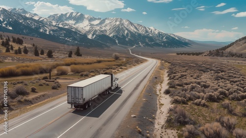 A delivery truck driving along the road against the backdrop of mountains. Bird's eye back view.