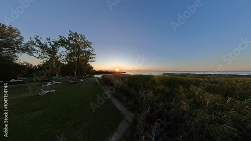 Timelapse of a garden with white beach chairs in front of Balaton Lake at sunset in Zamardi, Hungary photo