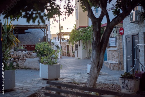 Fototapeta Naklejka Na Ścianę i Meble -  Narrow Greek streets in Hersonissos, Crete, Greece, lined with charming whitewashed buildings, colorful flowers, and vibrant local shops, exuding charm.