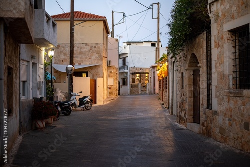 Fototapeta Naklejka Na Ścianę i Meble -  Narrow Greek streets in Hersonissos, Crete, Greece, lined with charming whitewashed buildings, colorful flowers, and vibrant local shops, exuding charm.