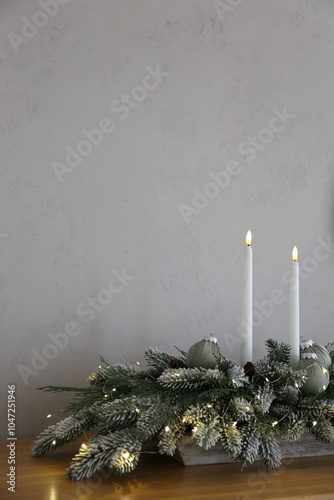 New Year's composition of fir branches and candles on the table